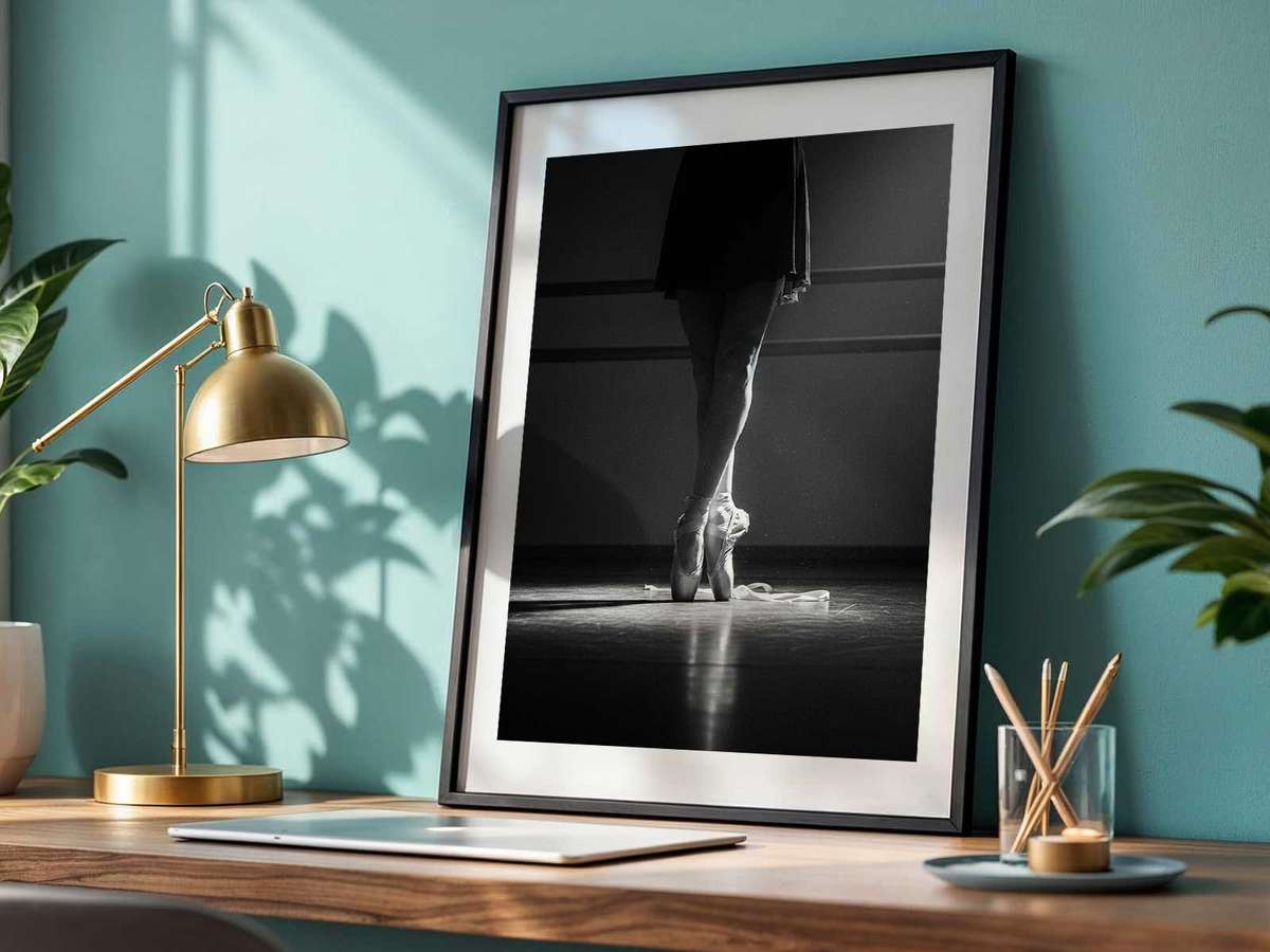 Silhouetted ballerina holding a poised arabesque against soft studio backlight, balancing strength and stillness