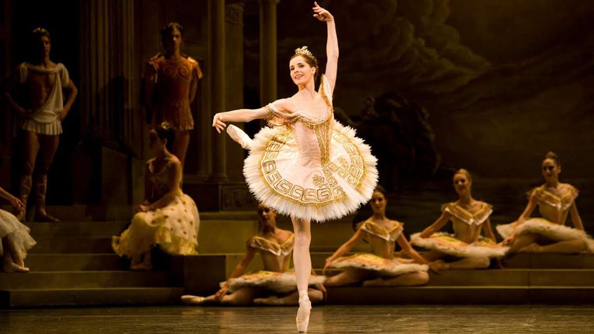 Darcey Bussell commanding the stage with expansive arms and focused gaze, projecting confidence to the audience