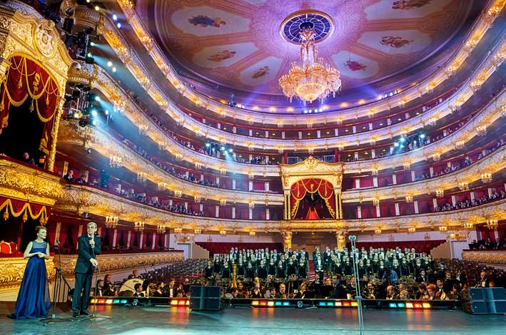 Principal Bolshoi dancer in a dramatic heroic pose centre stage under a spotlight
