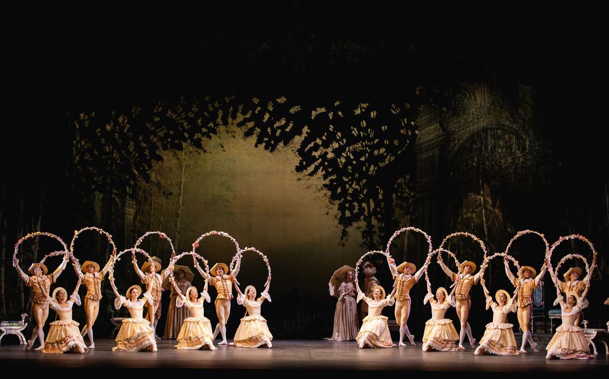 Lavish palace set of The Sleeping Beauty with chandeliers, velvet drapery and courtiers in period costume