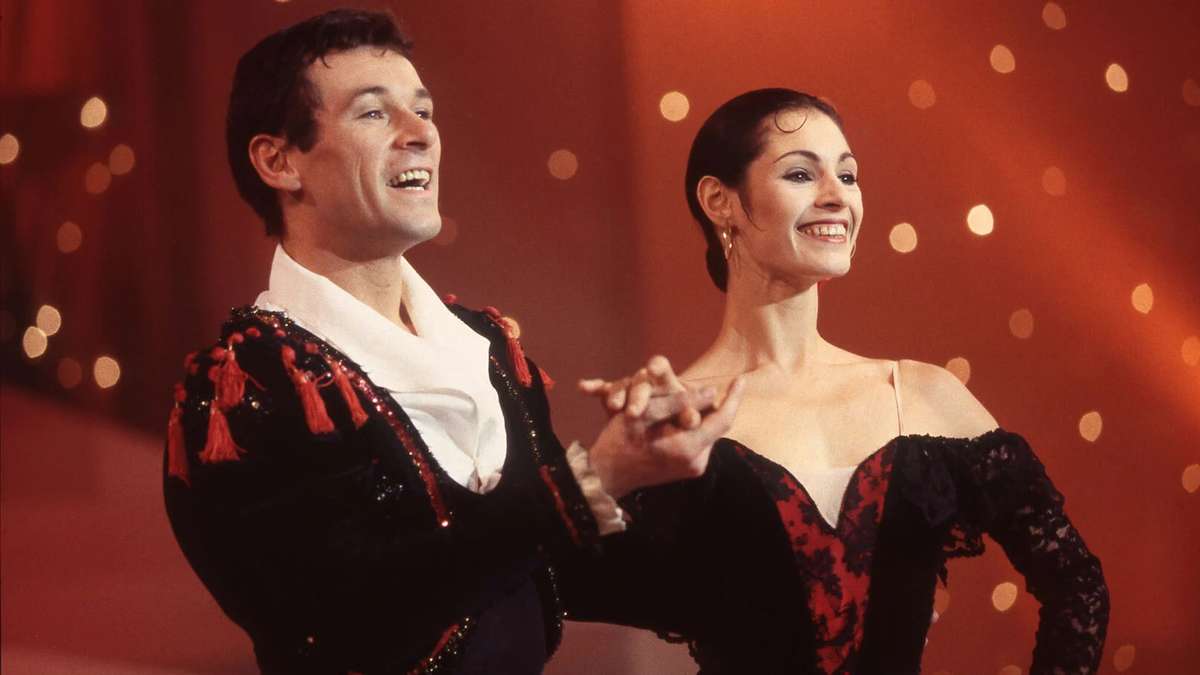 Marie‑Claude Pietragalla performing an intense pas de deux with a partner, bodies intertwined in a dramatic lift