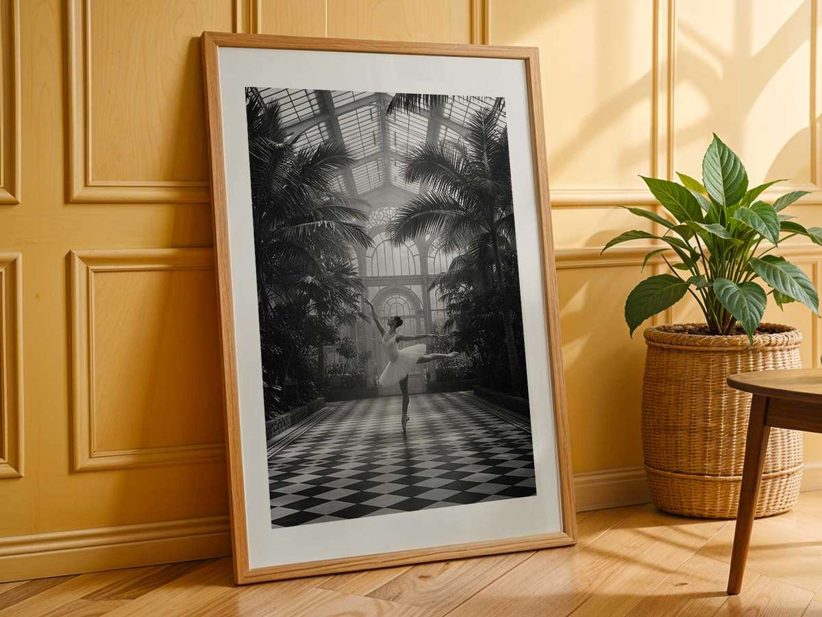 Monochrome framed image highlighting pointe shoes and leg line in strong contrast against a neutral background