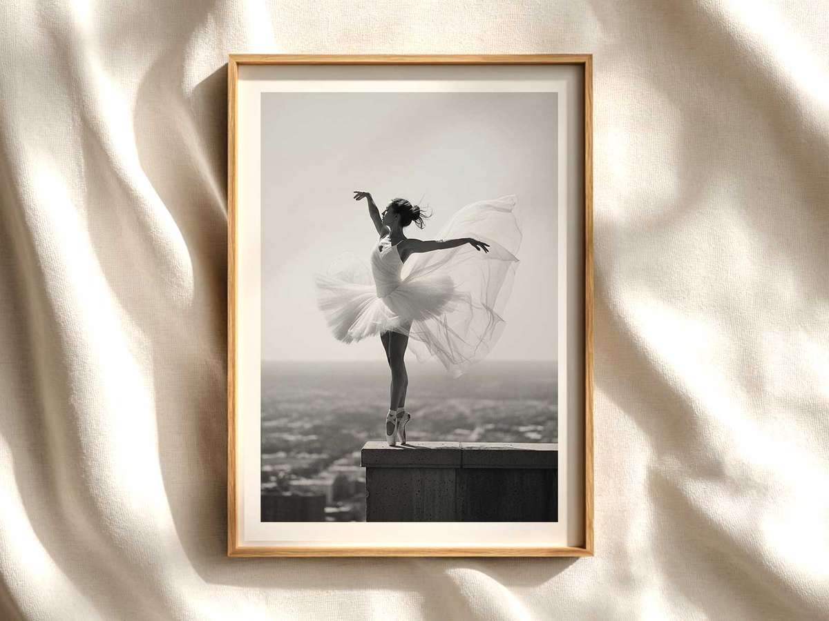 Ballerina in a suspended arabesque captured in profile with soft backlight highlighting the line of her leg and arm