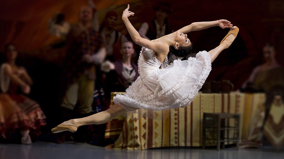 Natalia Osipova performing a high grand jeté on stage, muscles taut and expression fierce