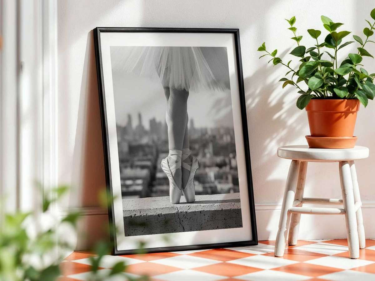 Side profile of a ballerina in black and white illuminated by a single stage light, silhouette cut against darkness