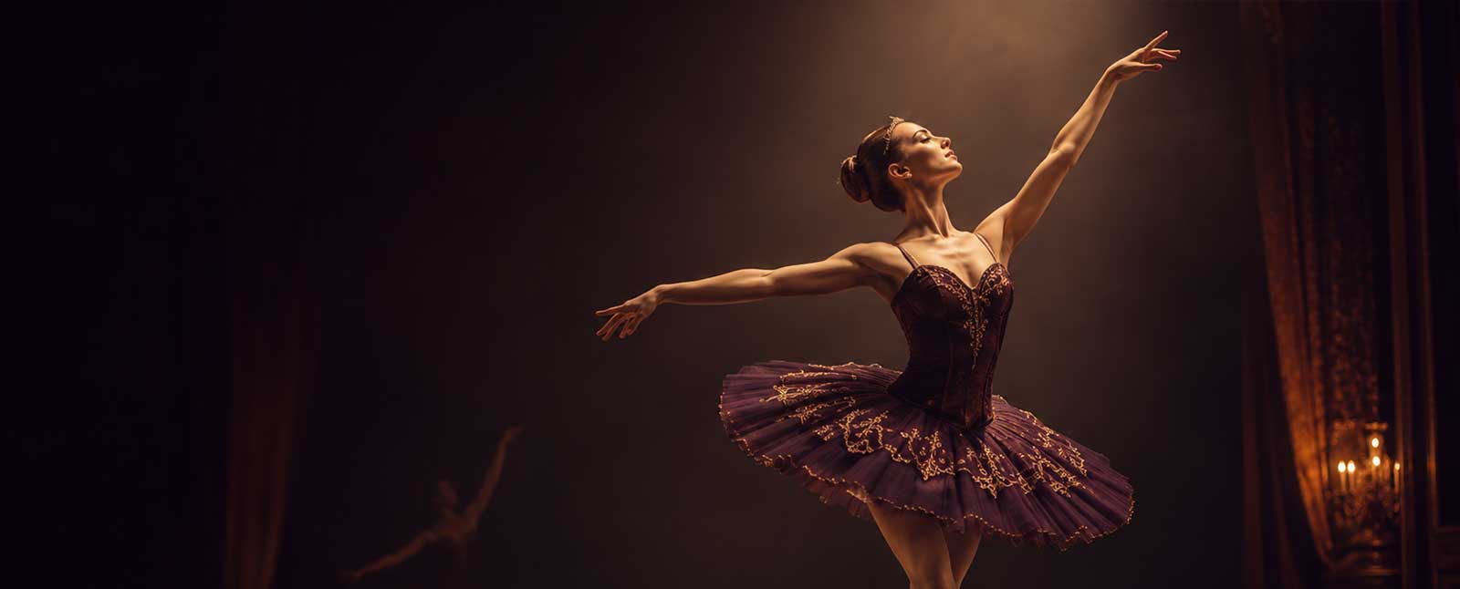 Ballerina in a soft tulle tutu gazing upward with graceful arm lines on a dimly lit stage
