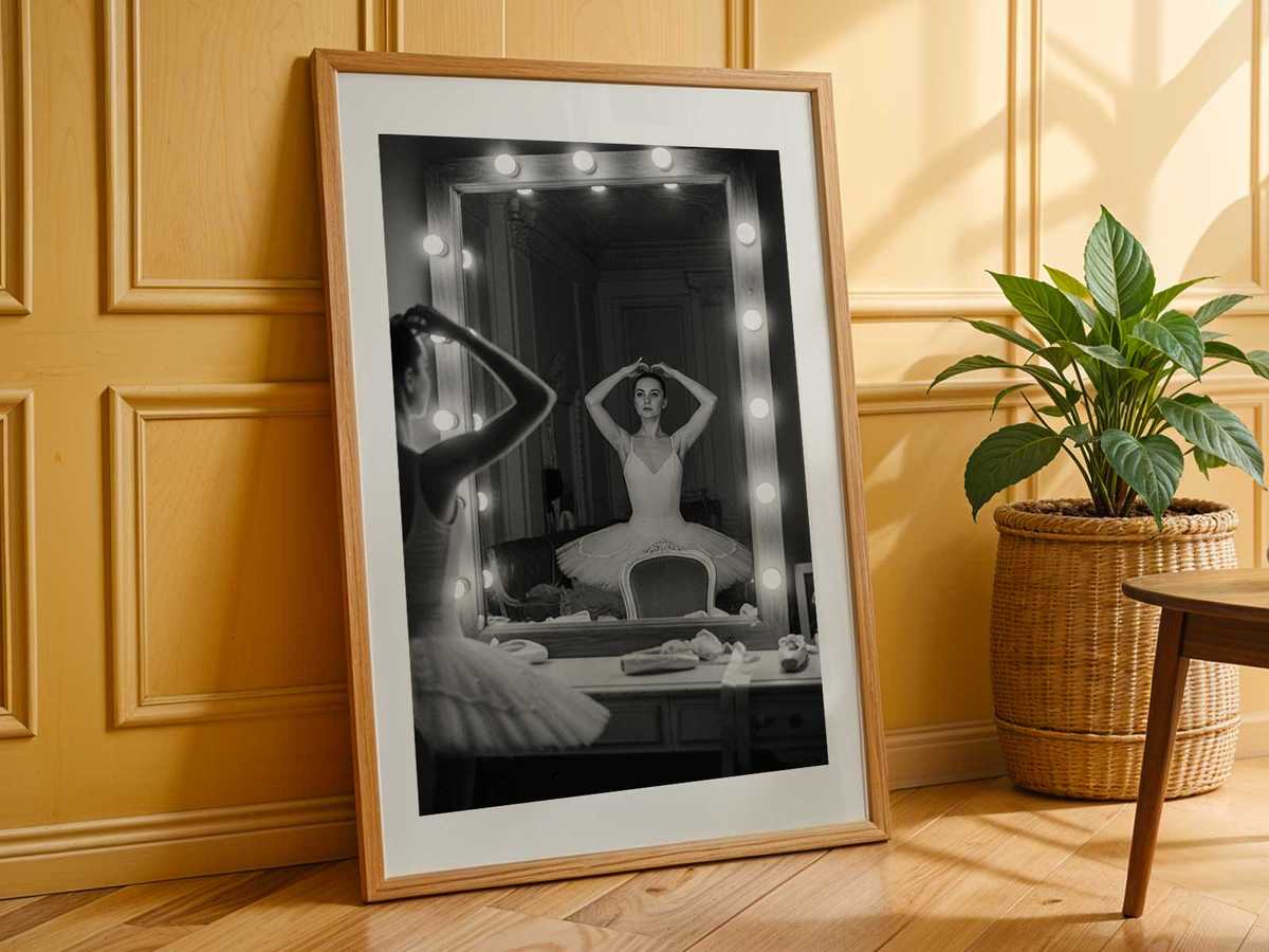 Low-contrast scene of a dancer and her reflected shadow in a dim studio, creating a layered composition of movement and…