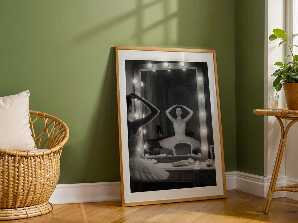 Three-quarter view of a dancer watching her mirrored profile as she sculpts an arm phrase, light pooling on polished…