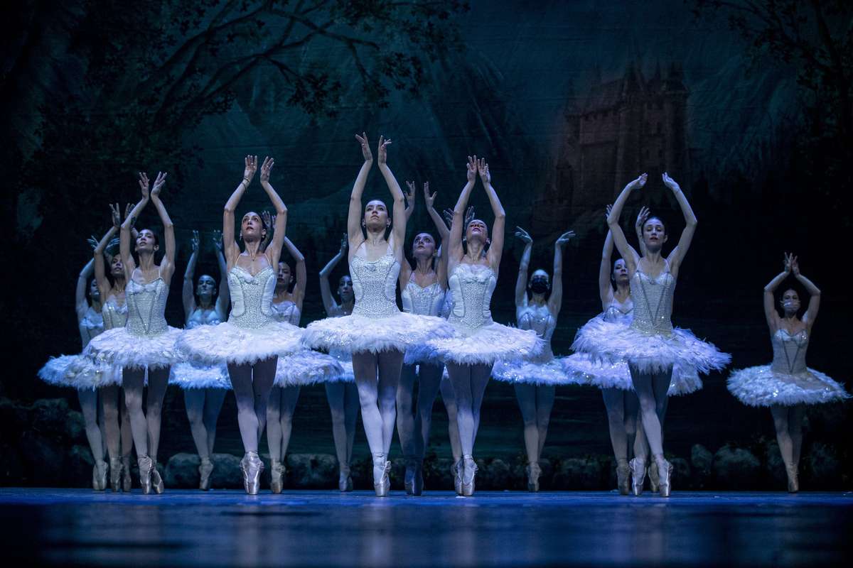 Staged tableau from the 1895 Petipa–Ivanov revival with dancers in white swan costumes on a moonlit lake set